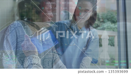 Patient in patterned sweater and doctor reviewing digital display at clinic table with stethoscope Patient in patterned sweater and doctor reviewing digital display at clinic table with stethoscope 135393699