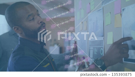 Pointing mid adult man holding marker to sticky notes, charts on board in office, copy space Pointing mid adult man holding marker to sticky notes, charts on board in office, copy space 135393875