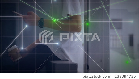 Man holding cup and tapping smartphone sitting on ledge in lounge with network overlay, copy space Man holding cup and tapping smartphone sitting on ledge in lounge with network overlay, copy space 135394739