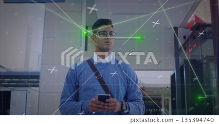 Standing man in blue sweater and glasses scanning lobby, with smartphone, crossbody bag, AR overlay Standing man in blue sweater and glasses scanning lobby, with smartphone, crossbody bag, AR overlay 135394740