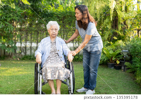 Caregiver help Asian elderly woman disability patient sitting on wheelchair in park. Caregiver help Asian elderly woman disability patient sitting on wheelchair in park. 135395178