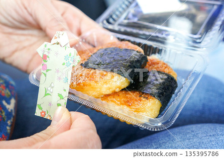 Holding a delicious, freshly made mochi made with rice and soy sauce 135395786