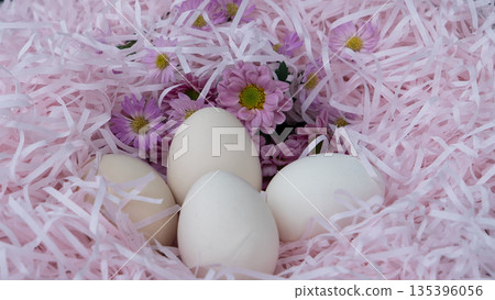 White Easter Eggs in Pink Nest with Flowers White Easter Eggs in Pink Nest with Flowers 135396056