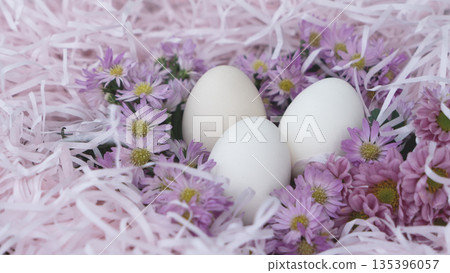 White Easter Eggs in Pink Nest with Flowers White Easter Eggs in Pink Nest with Flowers 135396057