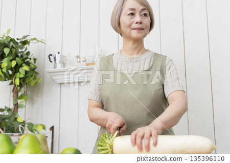 老婦人在廚房裡開心地做飯 135396110