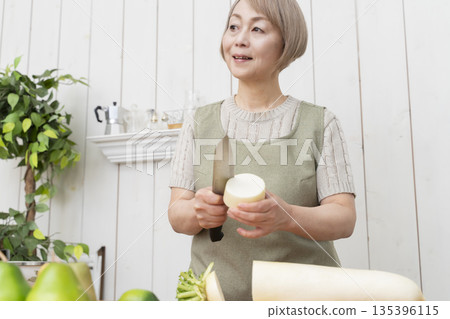 Senior woman happily cooking in the kitchen 135396115