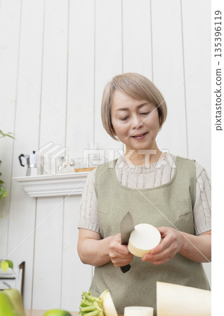 Senior woman happily cooking in the kitchen Senior woman happily cooking in the kitchen 135396119