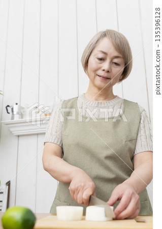 Senior woman happily cooking in the kitchen 135396128