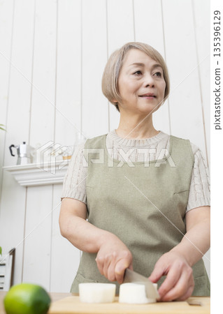 Senior woman happily cooking in the kitchen 135396129