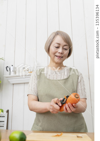 Senior woman happily cooking in the kitchen Senior woman happily cooking in the kitchen 135396134