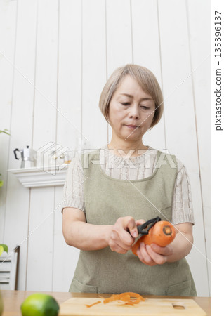Senior woman happily cooking in the kitchen 135396137
