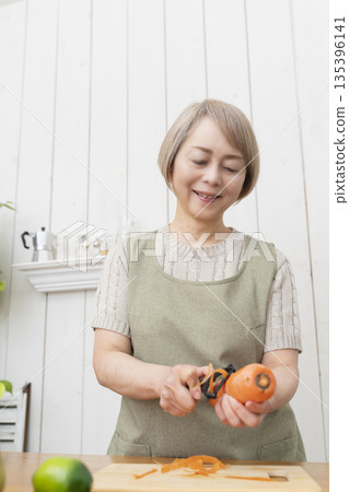Senior woman happily cooking in the kitchen Senior woman happily cooking in the kitchen 135396141