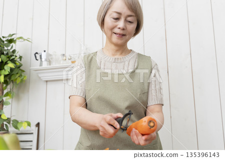 老婦人在廚房裡開心地做飯 135396143