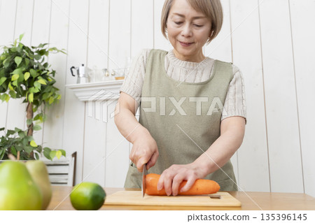 Senior woman happily cooking in the kitchen 135396145