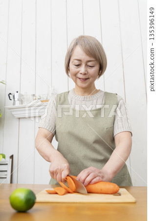 老婦人在廚房裡開心地做飯 老婦人在廚房裡開心地做飯 135396149