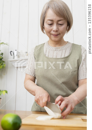 Senior woman happily cooking in the kitchen 135396158