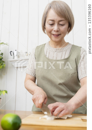 老婦人在廚房裡開心地做飯 135396160
