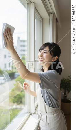 年終大掃除：一位女士正在努力擦窗戶。 135396225