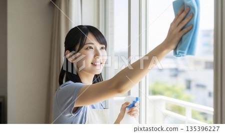Year-end cleaning: A woman working hard to clean windows 135396227