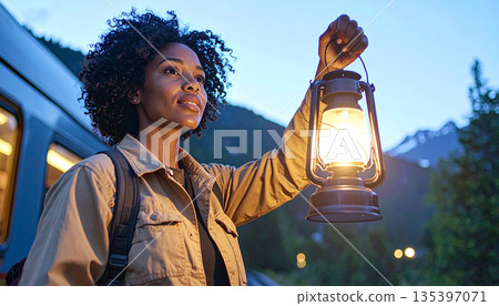 Close Up of Woman Stationmaster Signaling with Lantern at Blue Hour 135397071