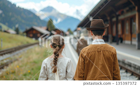 Back View of Swiss Children in Traditional Clothing Waiting at Remote Alpine Railway Station 135397372