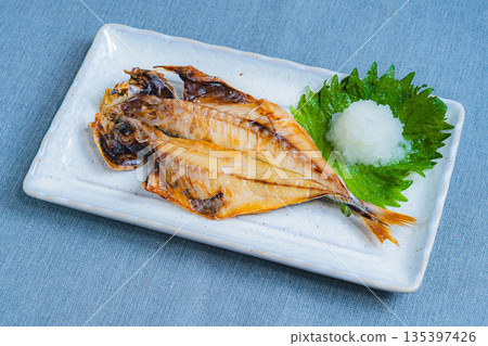 去骨竹莢魚片,盛於白色方盤中,配上磨碎的白蘿蔔和紫蘇葉。 去骨竹莢魚片,盛於白色方盤中,配上磨碎的白蘿蔔和紫蘇葉。 135397426