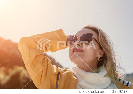Woman Sunglasses Sunshine - Portrait of a woman wearing sunglasses in bright sunshine. Woman Sunglasses Sunshine - Portrait of a woman wearing sunglasses in bright sunshine. 135397521