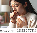 一位咳嗽且看起來很痛苦的女士 135397758