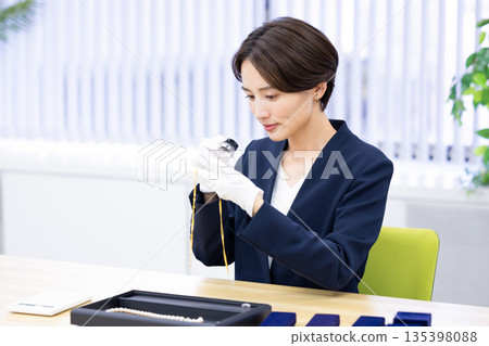 一位女士在採購公司的櫃檯評估一件商品 135398088