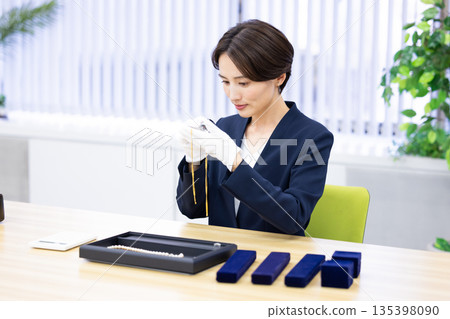 一位女士在採購公司的櫃檯評估一件商品 135398090