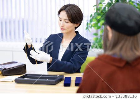 一位女士在採購公司的櫃檯評估一件商品 135398130