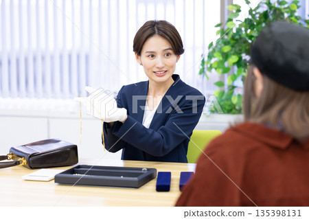 一位女士在採購公司的櫃檯評估一件商品 135398131