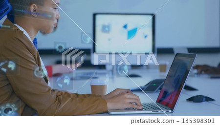 Typing professional working on laptop in boardroom, with monitor, coffee and smartphone, copy space 135398301