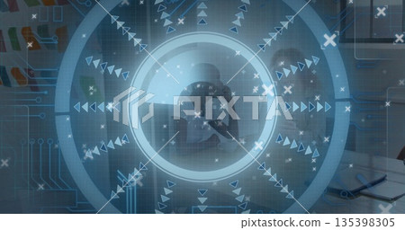 Analyzing colleagues in business attire consulting laptop and tablet at office table, with overlay 135398305