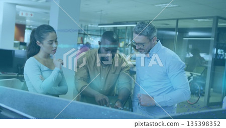 Pointing at digital display, three colleagues collaborating at modern office desks, with bicycle Pointing at digital display, three colleagues collaborating at modern office desks, with bicycle 135398352