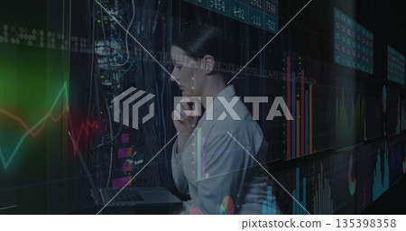 Analyzing woman in blazer reviewing financial charts in data center, with laptop and cables Analyzing woman in blazer reviewing financial charts in data center, with laptop and cables 135398358