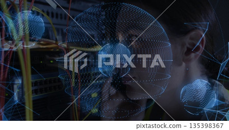 Holding handset, female technician fixing network links at rack with wireframe globes, copy space Holding handset, female technician fixing network links at rack with wireframe globes, copy space 135398367