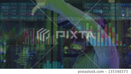 Using VR headset mid-adult man raising right arm selecting virtual charts in office, with graphs Using VR headset mid-adult man raising right arm selecting virtual charts in office, with graphs 135398373