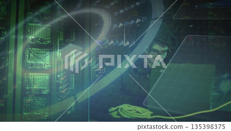 Working hooded engineer using laptop in server room with racks, yellow Ethernet cable, copy space 135398375