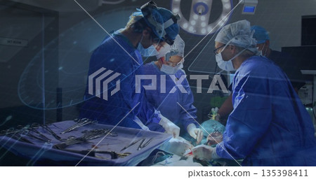 Working surgical team performing surgery under surgical lights in operating room, with instruments Working surgical team performing surgery under surgical lights in operating room, with instruments 135398411