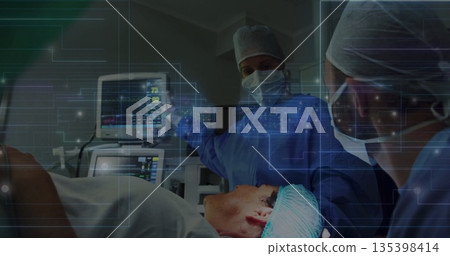 Pointing surgeon monitoring patient in OR with vital signs monitor and holographic overlay Pointing surgeon monitoring patient in OR with vital signs monitor and holographic overlay 135398414