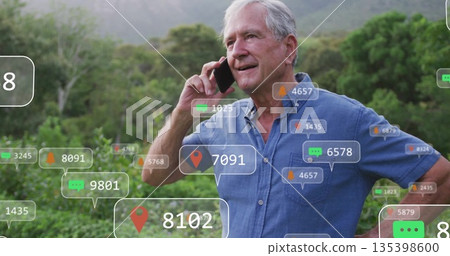Holding smartphone man wearing denim shirt speaking at forest foothill, with floating digital icons Holding smartphone man wearing denim shirt speaking at forest foothill, with floating digital icons 135398600