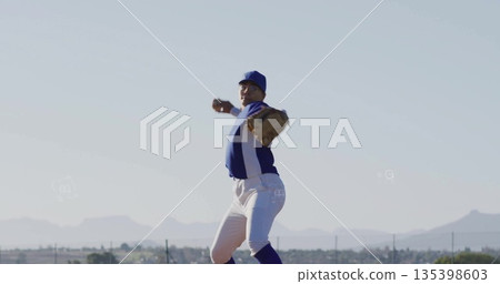 Pitching female baseball player winding arm with leather glove at baseball field, team jersey Pitching female baseball player winding arm with leather glove at baseball field, team jersey 135398603