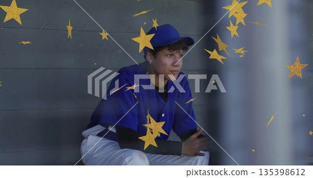 Sitting teenager in baseball uniform gazing at fence from dugout bench, with gold stars 135398612
