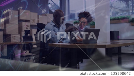 Gesticulating coworkers in office attire analyzing charts on laptop at conference table with plants 135398642