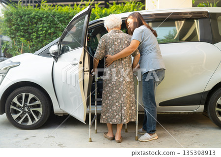 Caregiver help Asian elderly woman disability patient get into car. Caregiver help Asian elderly woman disability patient get into car. 135398913