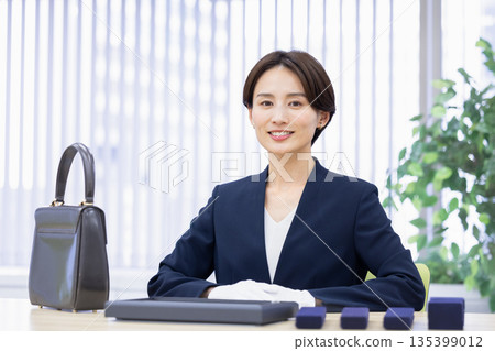 A woman assessing an item at a purchasing company's counter A woman assessing an item at a purchasing company's counter 135399012