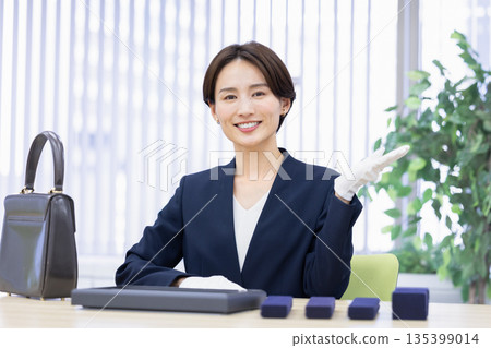A woman assessing an item at a purchasing company's counter A woman assessing an item at a purchasing company's counter 135399014