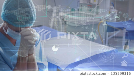 Standing surgeon in blue scrubs at operating table in surgical suite, with data overlay, copy space Standing surgeon in blue scrubs at operating table in surgical suite, with data overlay, copy space 135399316