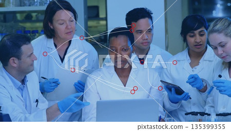 Examining results six research scientists collaborating at lab bench, with laptop and tablet 135399355